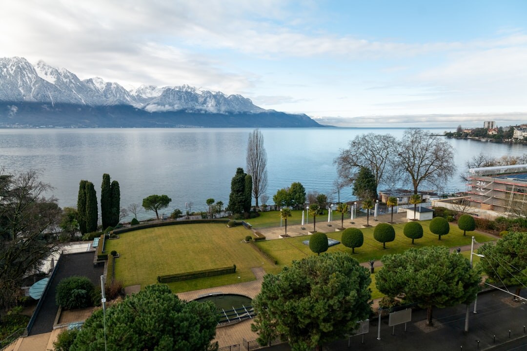Lake Geneva promenade at dusk with warm city lights reflecting on water
